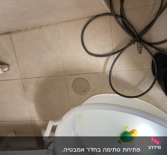 כבל אינסטלציה על רצפת חדר אמבטיה